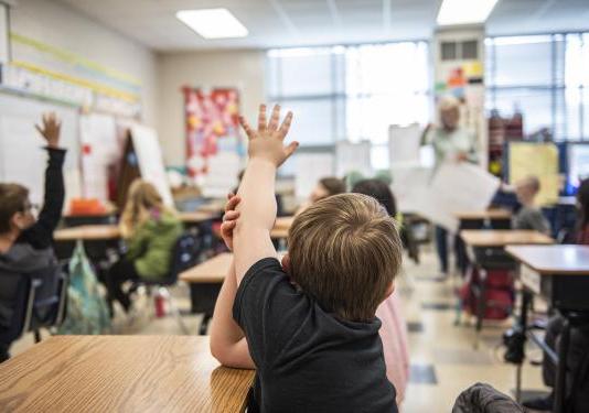 A child has a question in an elementary classroom